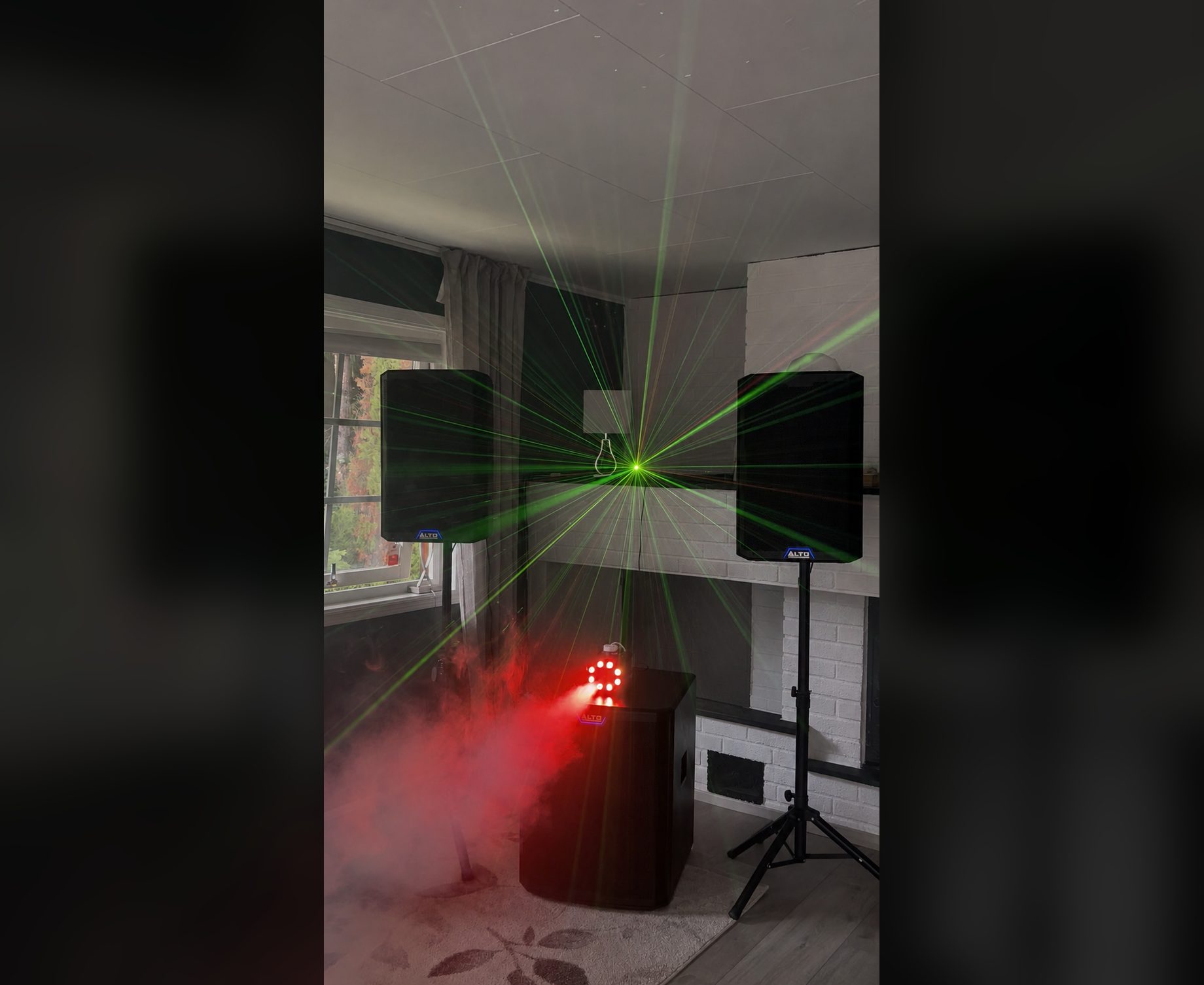 FestRiggen i mørkt rom: grønn laser gjennom røyk og rødt lys på subwooferen